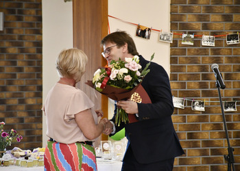 zdjęcie przedstawia dyrektora GOKU wręczającego kwiaty 
