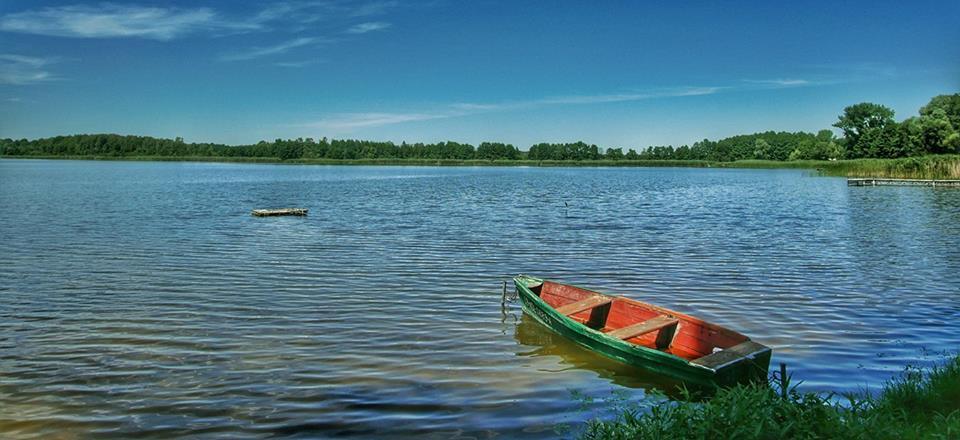 Zdjęcie przedstawiające jezioro i łódkę 