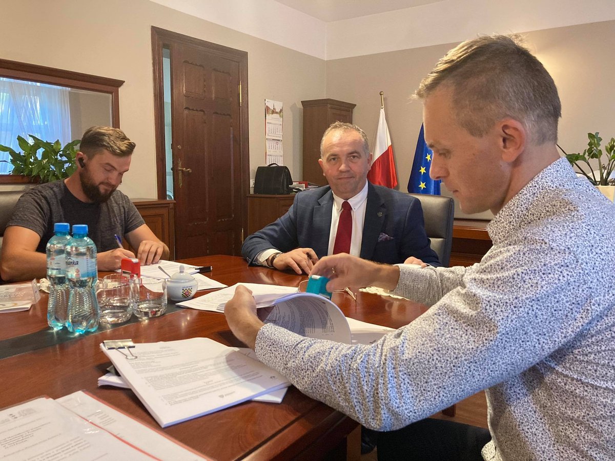 Zdjęcie przedstawia osoby podpisujące umowę