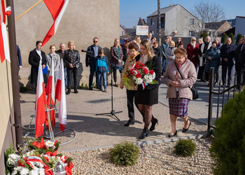 Zdjęcie przedstawia uczestników odsłonięcia tablicy upamiętniającej Marie Wojciech