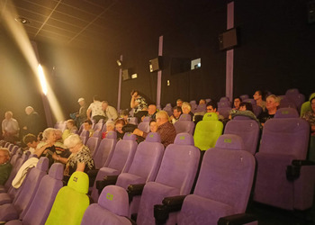 Zdjęcie uczestników klubu seniora w sali kinowej