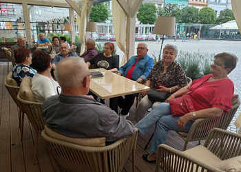 Uczestnicy klubu seniora i opiekunowie zwiedzają rynek w Lesznie