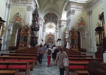 Zdjęcia uczestników klubu seniora i opiekunów wycieczki w kościele w Lesznie