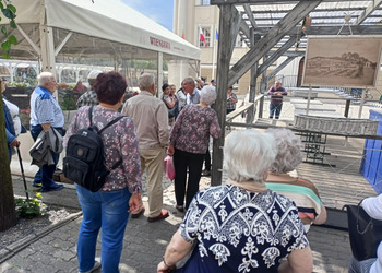 Uczestnicy klubu seniora i opiekunowie zwiedzają rynek w Lesznie