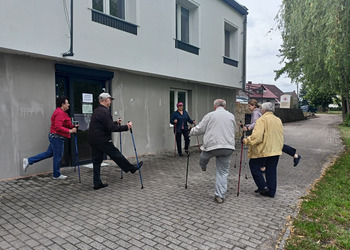 Zdjęcie przedstawia uczestników Klubu Seniora podczas zajęć nordic walking