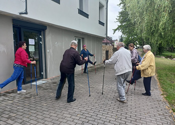 Zdjęcie przedstawia uczestników Klubu Seniora podczas zajęć nordic walking