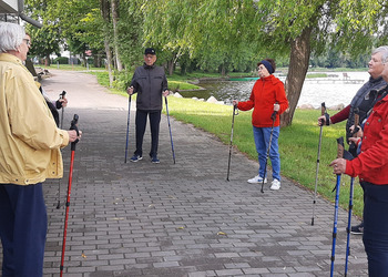 Zdjęcie przedstawia uczestników Klubu Seniora podczas zajęć nordic walking