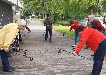 Zdjęcie przedstawia uczestników Klubu Seniora podczas zajęć nordic walking