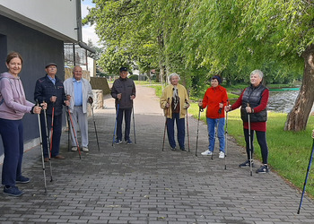 Zdjęcie przedstawia uczestników Klubu Seniora podczas zajęć nordic walking