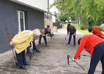 Zdjęcie przedstawia uczestników Klubu Seniora podczas zajęć nordic walking