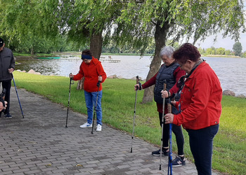 Zdjęcie przedstawia uczestników Klubu Seniora podczas zajęć nordic walking