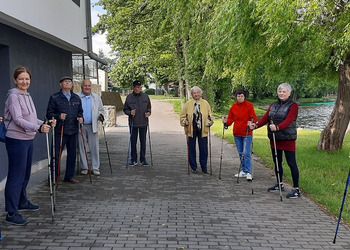 Zdjęcie przedstawia uczestników Klubu Seniora podczas zajęć nordic walking