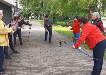 Zdjęcie przedstawia uczestników Klubu Seniora podczas zajęć nordic walking