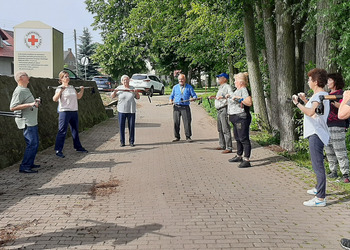 Zdjęcie przedstawia uczestników Klubu Seniora podczas zajęć nordic walking