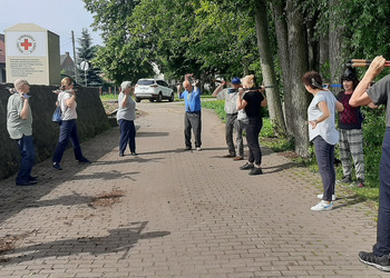 Zdjęcie przedstawia uczestników Klubu Seniora podczas zajęć nordic walking