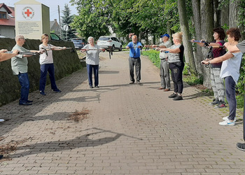 Zdjęcie przedstawia uczestników Klubu Seniora podczas zajęć nordic walking