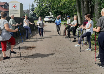 Zdjęcie przedstawia uczestników Klubu Seniora podczas zajęć nordic walking