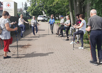 Zdjęcie przedstawia uczestników Klubu Seniora podczas zajęć nordic walking