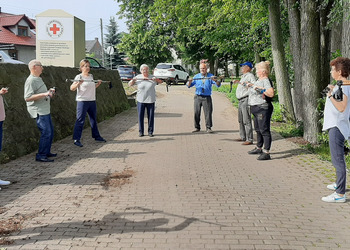 Zdjęcie przedstawia uczestników Klubu Seniora podczas zajęć nordic walking