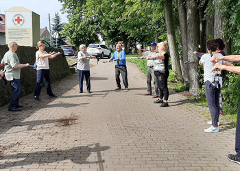 Zdjęcie przedstawia uczestników Klubu Seniora podczas zajęć nordic walking