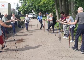 Zdjęcie przedstawia uczestników Klubu Seniora podczas zajęć nordic walking