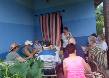 Zdjęcie przedstawia Seniorów siedzących przy stole