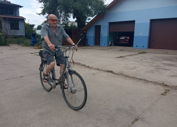 Zdjęcie przedstawia Seniora jadącego na rowerze