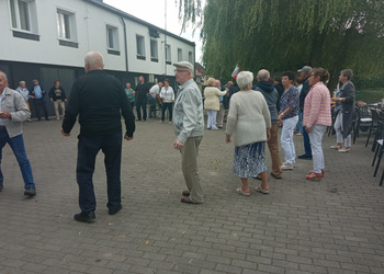 Zdjęcie przedstawia tańczących seniorów