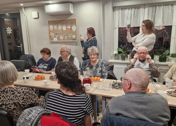 Zdjęcie przedstawia Seniorów zasiadających przy stole