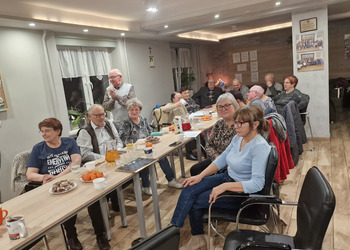 Zdjęcie przedstawia Seniorów zasiadających przy stole