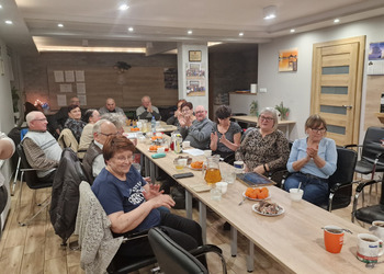 Zdjęcie przedstawia Seniorów zasiadających przy stole