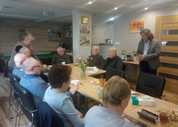 zdjęcie przedstawia seniorów podczas spotkania z antykwariuszem 