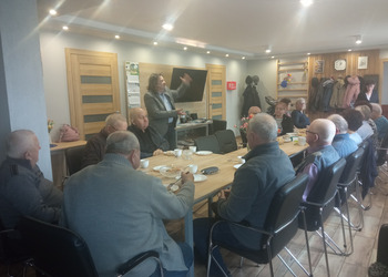 zdjęcie przedstawia seniorów podczas spotkania z antykwariuszem 