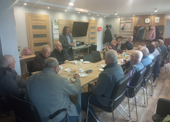 zdjęcie przedstawia seniorów podczas spotkania z antykwariuszem 