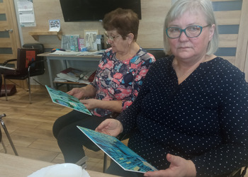 zdjęcie przedstawia seniorów podczas spotkania z antykwariuszem 