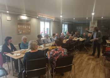 zdjęcie przedstawia seniorów podczas spotkania z antykwariuszem 