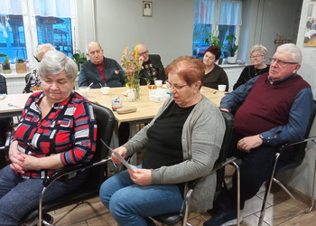 zdjęcie przedsawia seniorów podczas wieczoru poetyckiego 