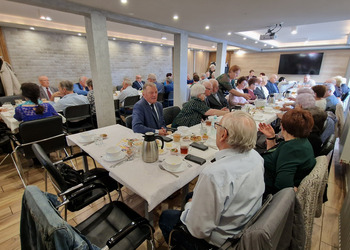 zdjęcie przedstawia seniorów zasiadających przy stole 