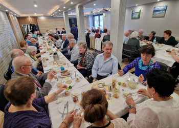 zdjęcie przedstawia seniorów zasiadających przy stole 