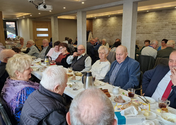 zdjęcie przedstawia seniorów zasiadających przy stole 