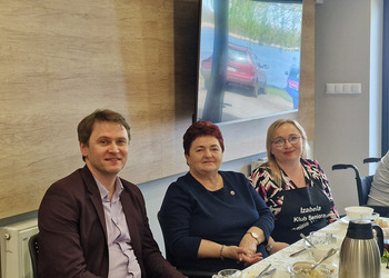 zdjęcie przedstawia seniorów zasiadających przy stole 