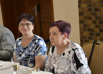 zdjęcie przedstawia gości zasiadających przy stole