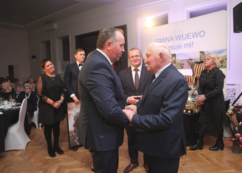 zdjęcie przedstawia starsze osoby składające życzenia 