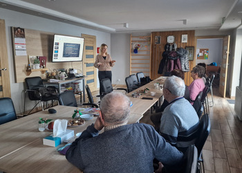 seniorzy oraz osoba prowadząca podczas prelekcji