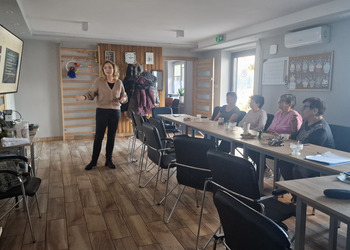 seniorzy oraz osoba prowadząca podczas prelekcji