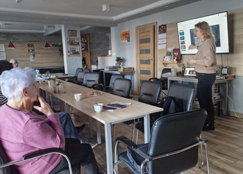 seniorzy oraz osoba prowadząca podczas prelekcji