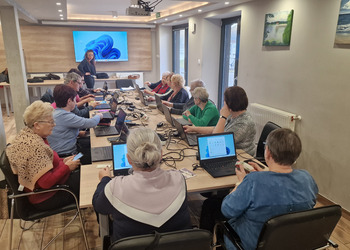 na zdjęciu seniorzy podczas kursu komputerowego 