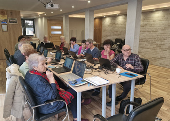 na zdjęciu seniorzy podczas kursu komputerowego 