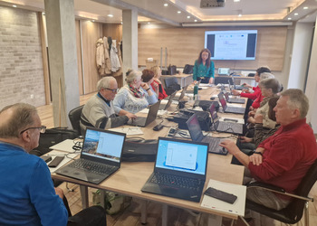 na zdjęciu seniorzy podczas kursu komputerowego 