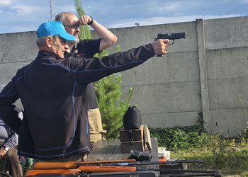 Zdjęcie przedstawia uczestników Klubu Seniora podczas zajęć na strzelnicy